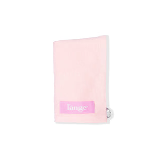 The blush-colored hair wrap towel is folded with the logo and suction cup showing.