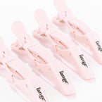A frontal view of four pink blow dry clips lined up with the logo showing.