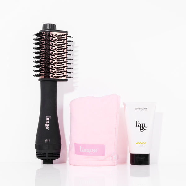 Black teardrop titanium dryer brush with blush Hair Wrap Towel, white bottle of Treatment A Deux