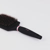 Zoomed in video of Black Siena Paddle Brush features black bristles with boar with blush L'ange logo